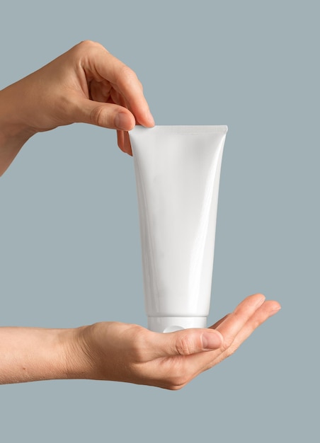 Crème tube in de hand Schoonheidsproduct pakket blanco verpakking mockup