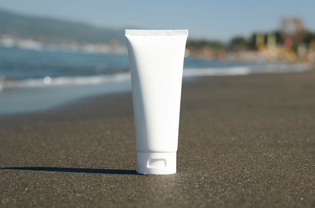 Crème tube mockup staat op nat zand op de achtergrond van het strand en de zee zonnebrandcrème lotion con