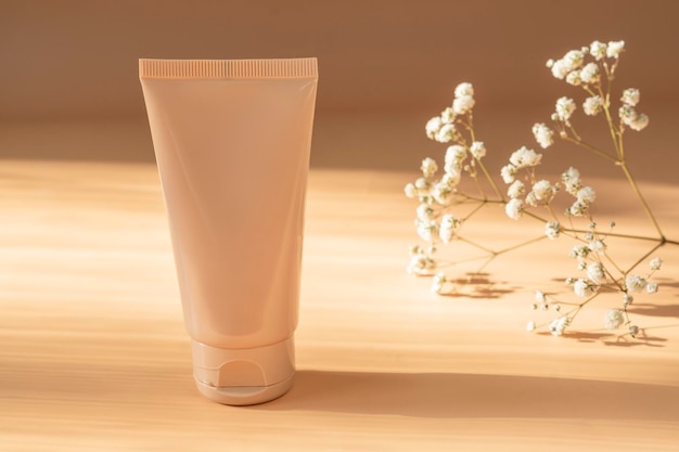 Crème tube op heldere zonnige beige achtergrond Cosmetisch huidverzorgingsproduct leeg plastic pakket Beige merkloze lotion balsem handcrème mockup Zonnebrandcrème fles