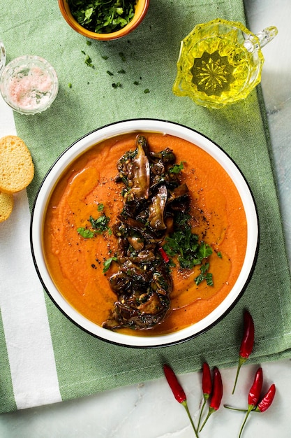 Crèmesoep van rode linzen met tomaten en gebakken bospaddestoelen op tafel gezond veganistisch opwarmend voedsel voor het hele gezin