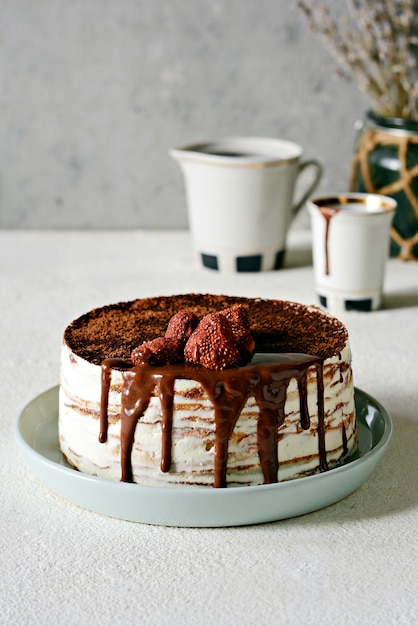 Crêpe cake gemaakt van dunne crêpe met botercrème, cacao, chocolade, gevriesdroogde aardbeien.