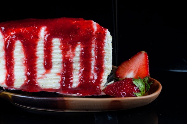 Crepe cake with strawberry sauce and fresh strawberries.