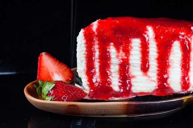 Crepe cake with strawberry sauce and fresh strawberries.