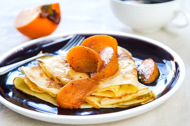 Crêpe met gebakken persimmon bij de koffie