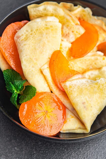 Crêpe persimmon dunne pannenkoeken fruit ontbijt zoet dessert gezonde maaltijd eten snack op tafel