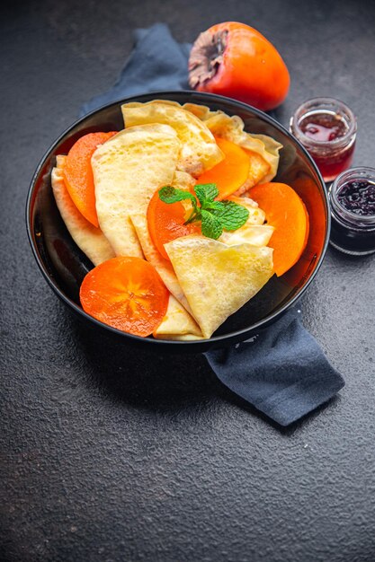 Crepe persimmon thin pancakes fruit breakfast sweet dessert healthy meal food snack on the table