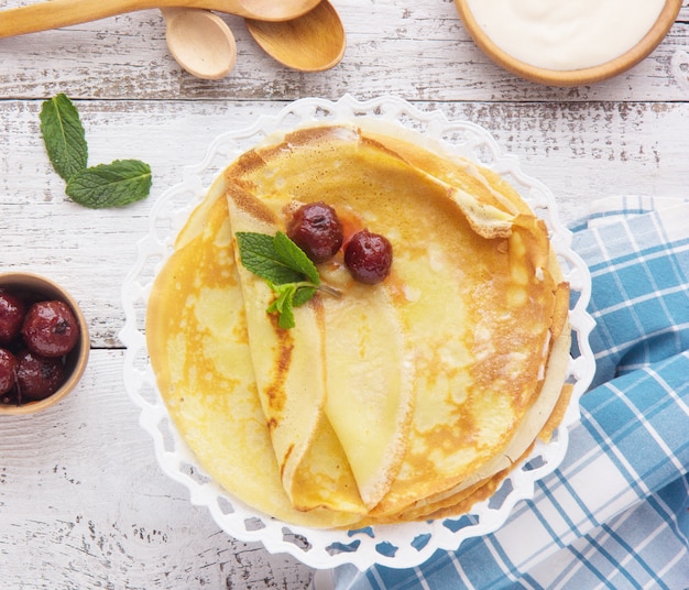 Crepes (Blini) and Honey on wooden background, top view, copy space. Homemade thin crepes for breakfast or dessert.