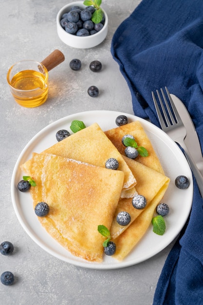 사진 하얀 접시에 신선한 블루베리와 가루 설탕을 곁들인 크레페 복사 공간