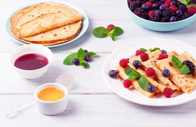 Crepes with berries breakfast selective focus on a white wooden table horizontal no people