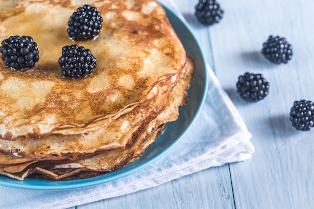 Crepes with blackberries on the wooden table