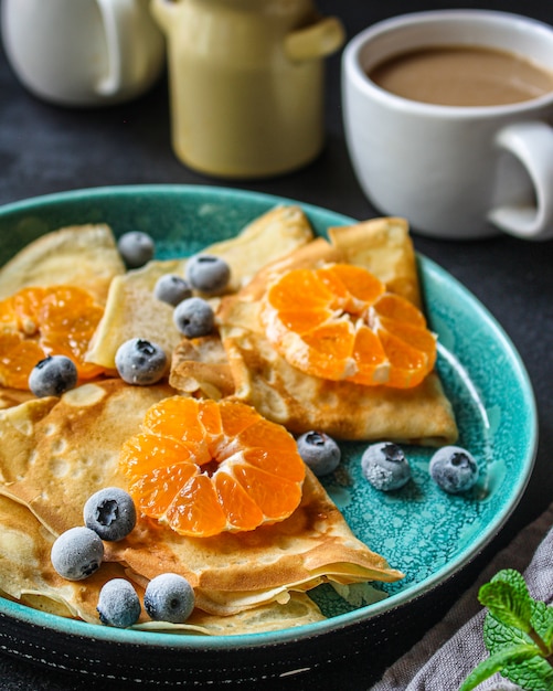 Crepes with citrus, jam and berries