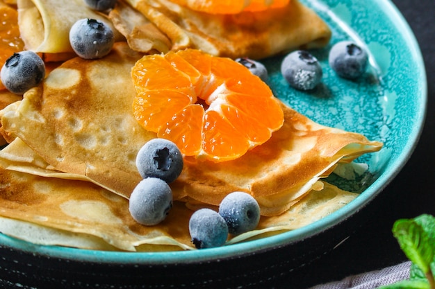 crepes with citrus, jam and berries
