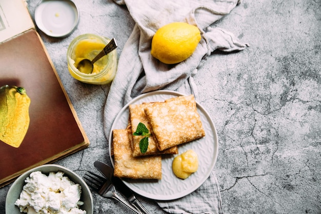 Crepes con ricotta fatta in casa e cagliata di limone su un piatto grigio