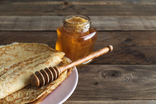 Foto crepe con miele su uno sfondo di legno copia spazio