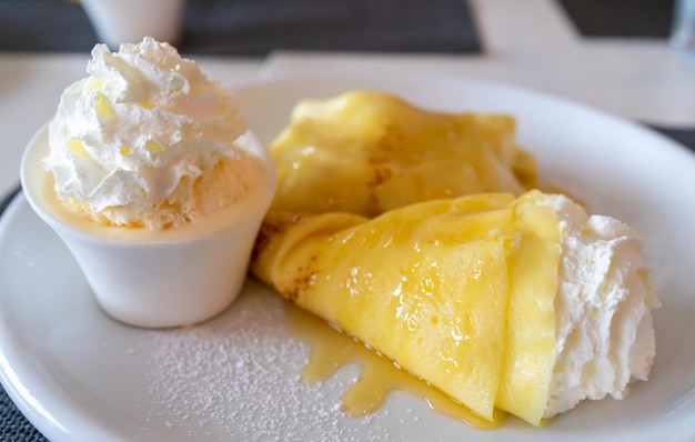 Crepes with vanilla ice cream in white plate