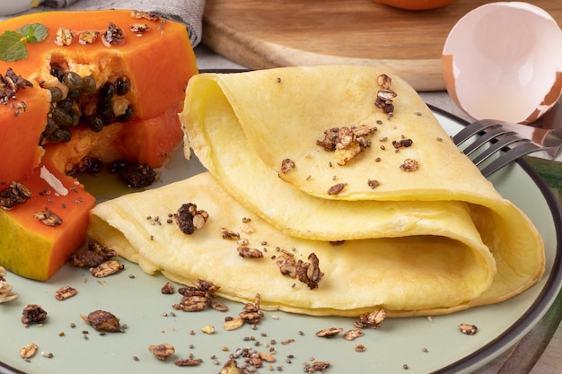 Crepioca e papaia con muesli e miele, fuoco selettivo.