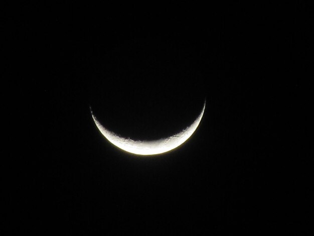 A crescent moon is seen in the dark sky.