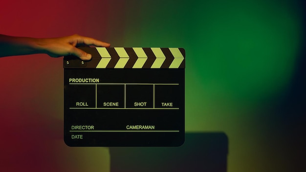 Crew hand holding plastic and wooden film slate board against
camera