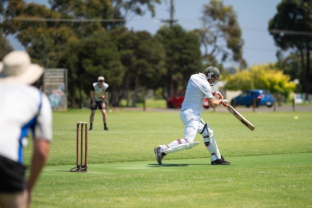 cricketer batting on a cricket pitch a local cricket match being played on a green cricket oval in summer in australia