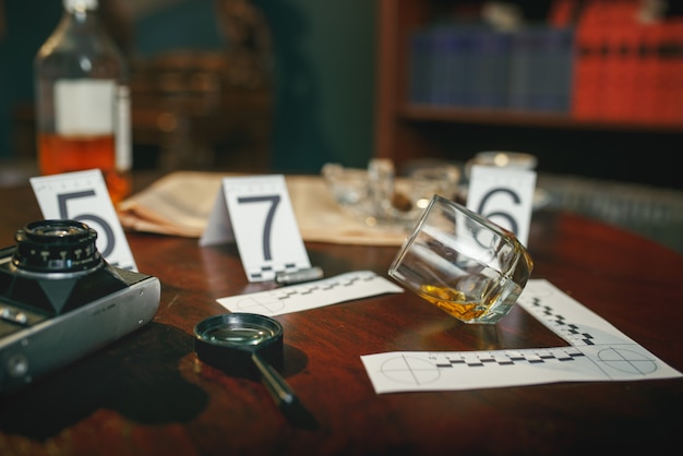Photo crime scene, evidence with numbers on the table closeup, nobody. detective investigation concept, magnifying glass and retro photo camera, vintage style room interior on background