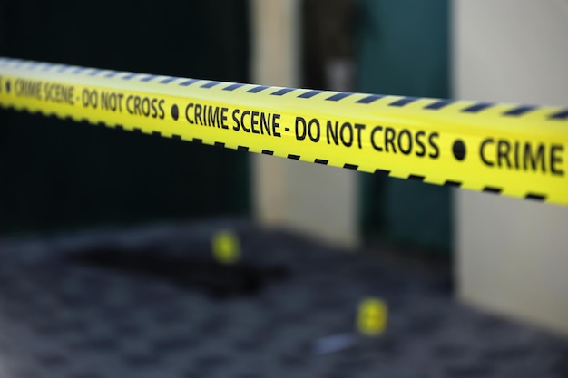 Crime scene tape for covering the area cordon Yellow tape with blurred forensic law enforcement background in cinematic tone