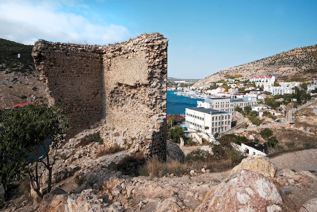 Crimea. Balaklava. October 2010. Bay. Panoramic top view of the sea and boats. Rocks and water and roofs of city houses. Fortress on the mountain