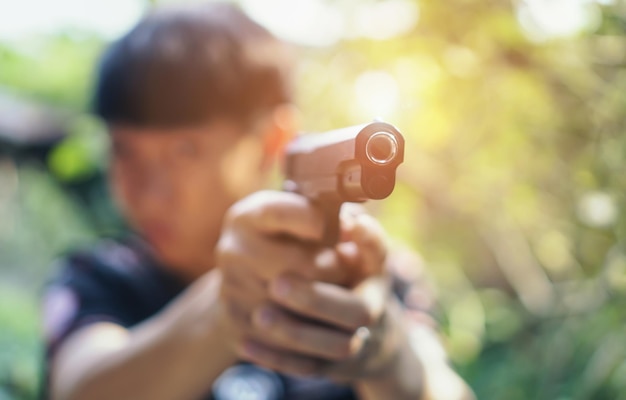 Photo criminal aiming gun outdoors