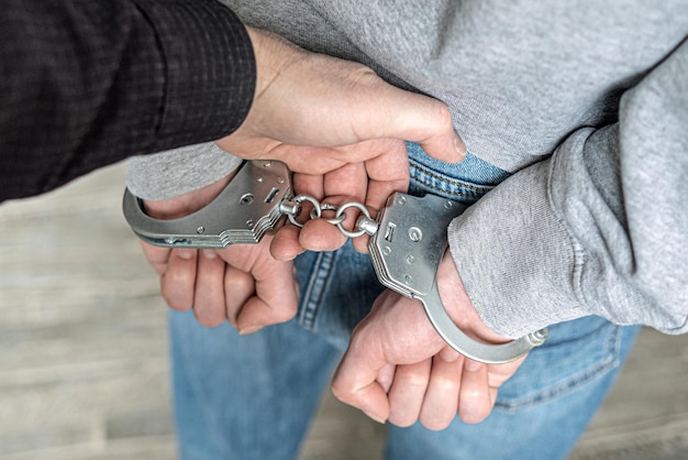 A criminal has been detained Hands are wound back handcuffs are put on to prevent aggression