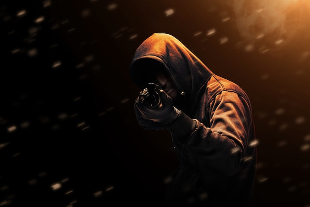 Преступник в скрытой маске, указывая на дробовик с драматическим фоном