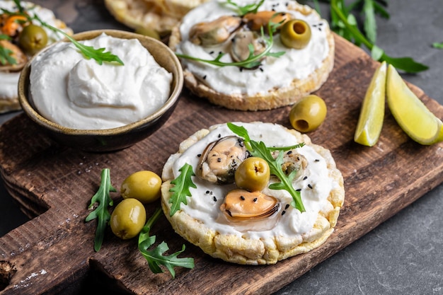 Crisp breads Homemade Mussels bruschetta toast with soft cheese and arugula banner menu recipe place for text top view