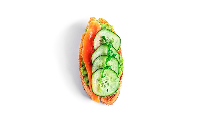 Crispbread sandwich with guacamole, salmon, arugula, cucumber isolated. Bruschetta with avocado. Healthy breakfast