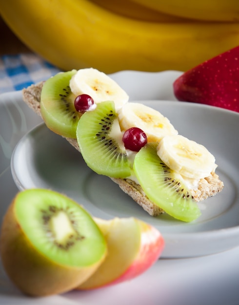 Crispbread with whipped cream, banana and kiwi