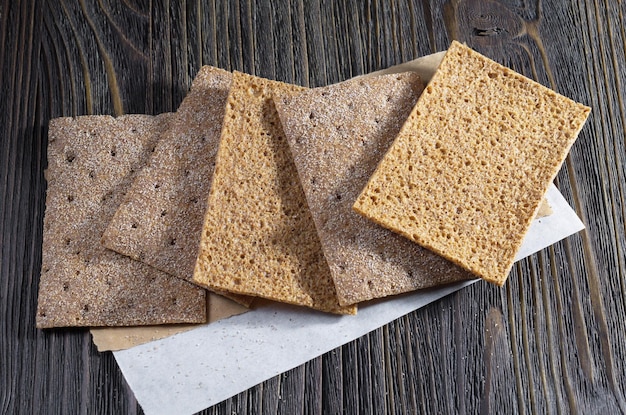 Crisps rye bread on dark wooden background closeup