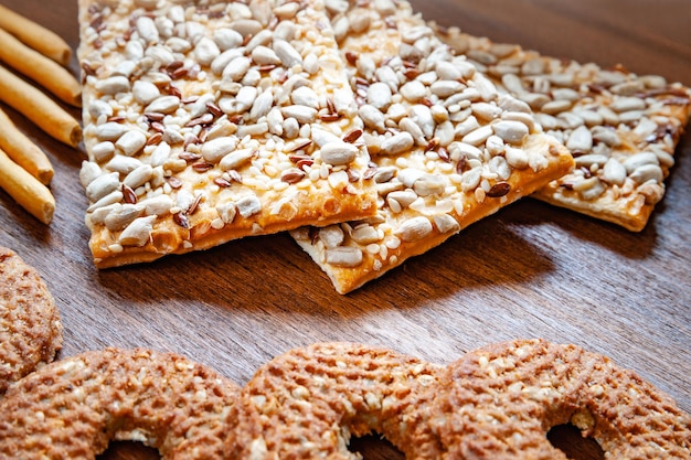 Crispy biscuit crackers with flax and sesame sunflower seeds on wooden background