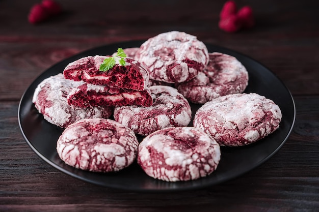 Crispy biscuits on black plate Cookies Red velvet with cream filling Half of broken cookie and whole cookies decorated powdered sugar holiday baking recipe colorful food homamed bakery