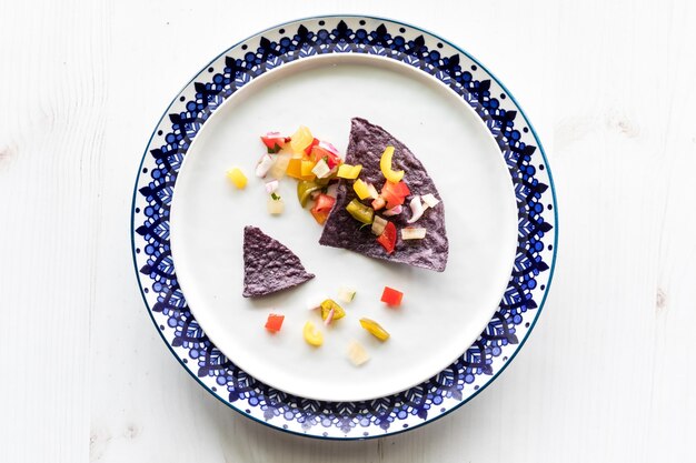 Crispy blue corn tortilla chips con salsa fresca in cima