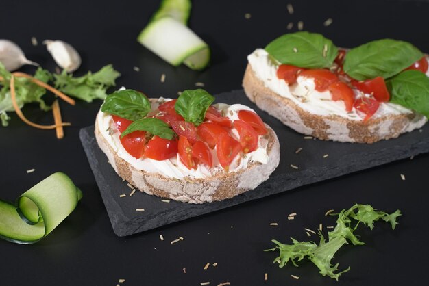 Foto aperitivi di pane croccante con pomodori al formaggio e basilico da spalmare