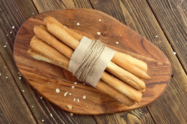 Crispy bread sticks on wooden table