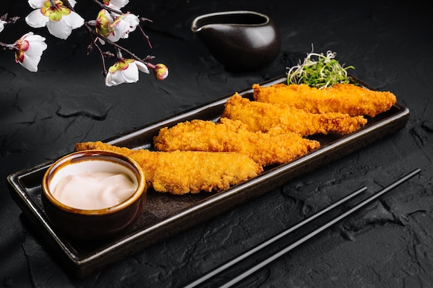 Crispy breaded shrimp with dipping sauce and cherry blossoms