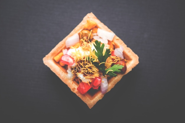 Crispy Canape or canapÃÂ© is a starter recipe from India - Round or square shaped Puri Filled with Yogurt and potato , chat, sev, tamarind sauce etc. selective focus