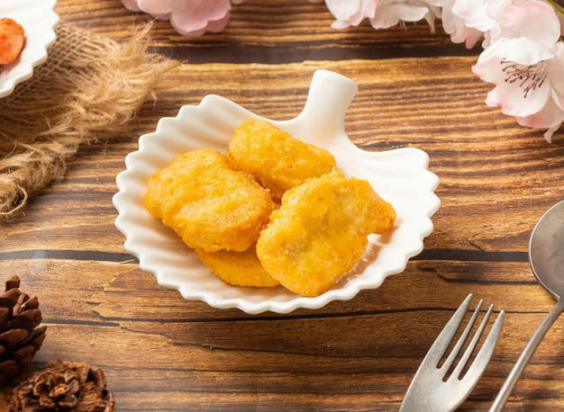 Crispy chicken nuggets in dish side view on wooden table taiwan style food