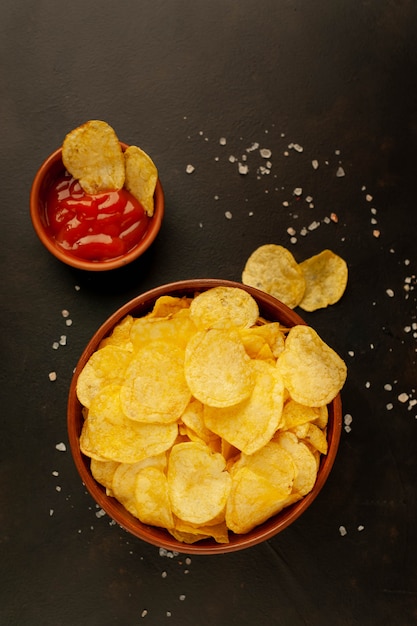 Crispy chips in a bowl on a stone background