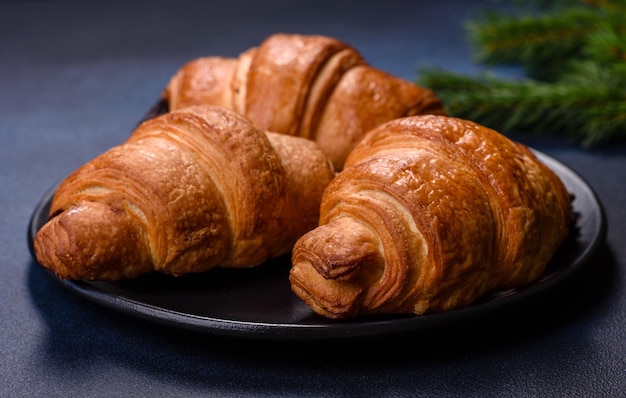 Crispy chocolate croissant with Christmas decorations on wooden cutting board