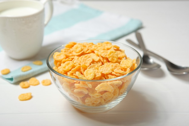 Cornflakes croccanti con latte per colazione sul primo piano del tavolo