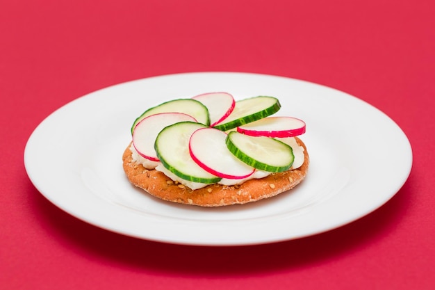 Crispy cracker sandwich with cream cheese fresh cucumber and radish