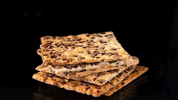 Crispy crackers with sunflower seeds and sesame on a black