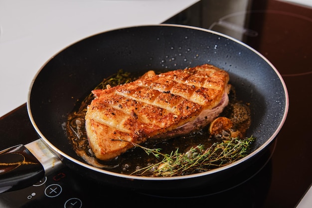 Crispy crosswise cut duck breast in frying pan