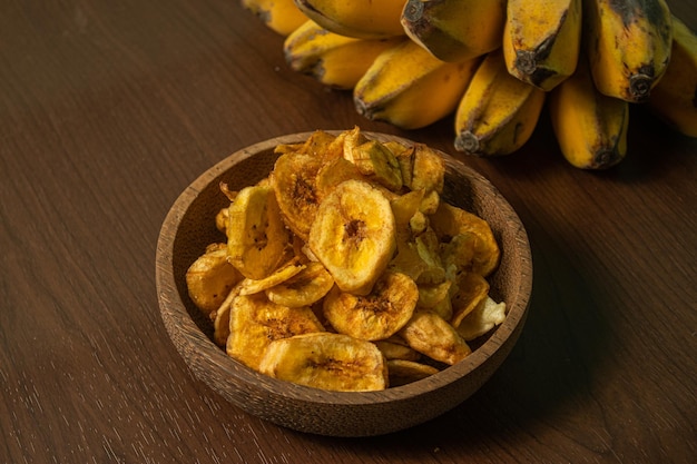 Crispy and delicious banana chips on a wooden background