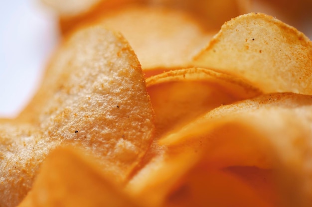 Crispy and delicious potato chips on white background