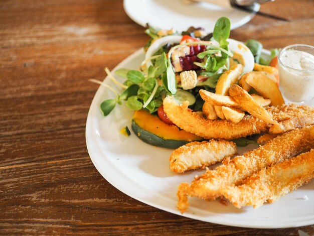 Photo crispy fish stick served with fresh salad and creamy mayonnaise dressing healthy food concept